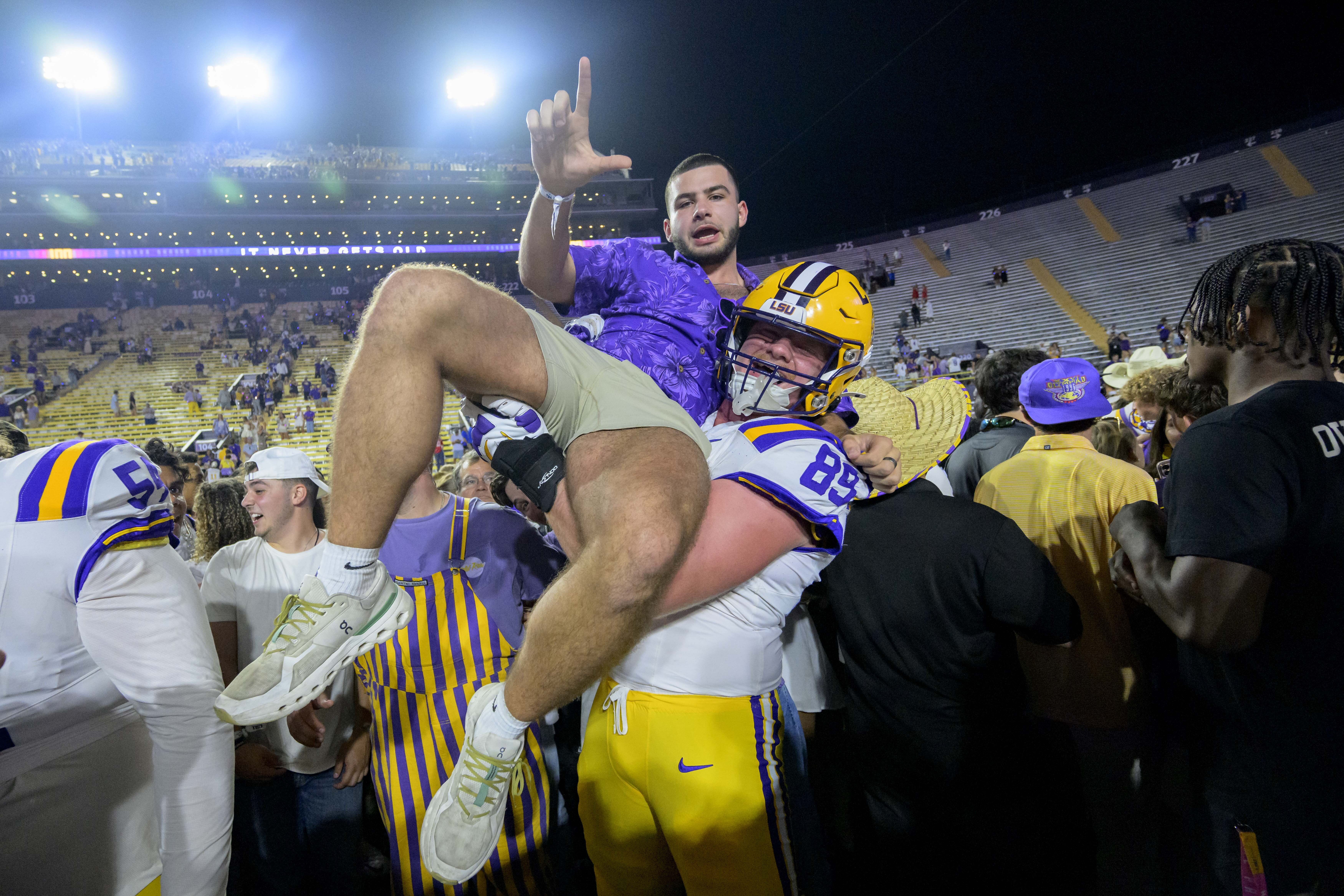 LSU offensive lineman Bo Bordelon (89) celebrates with LSU fans after they rushed the field after the team's overtime victory over Mississippi during an NCAA college football game in Baton Rouge, La., Saturday, Oct. 12, 2024. 