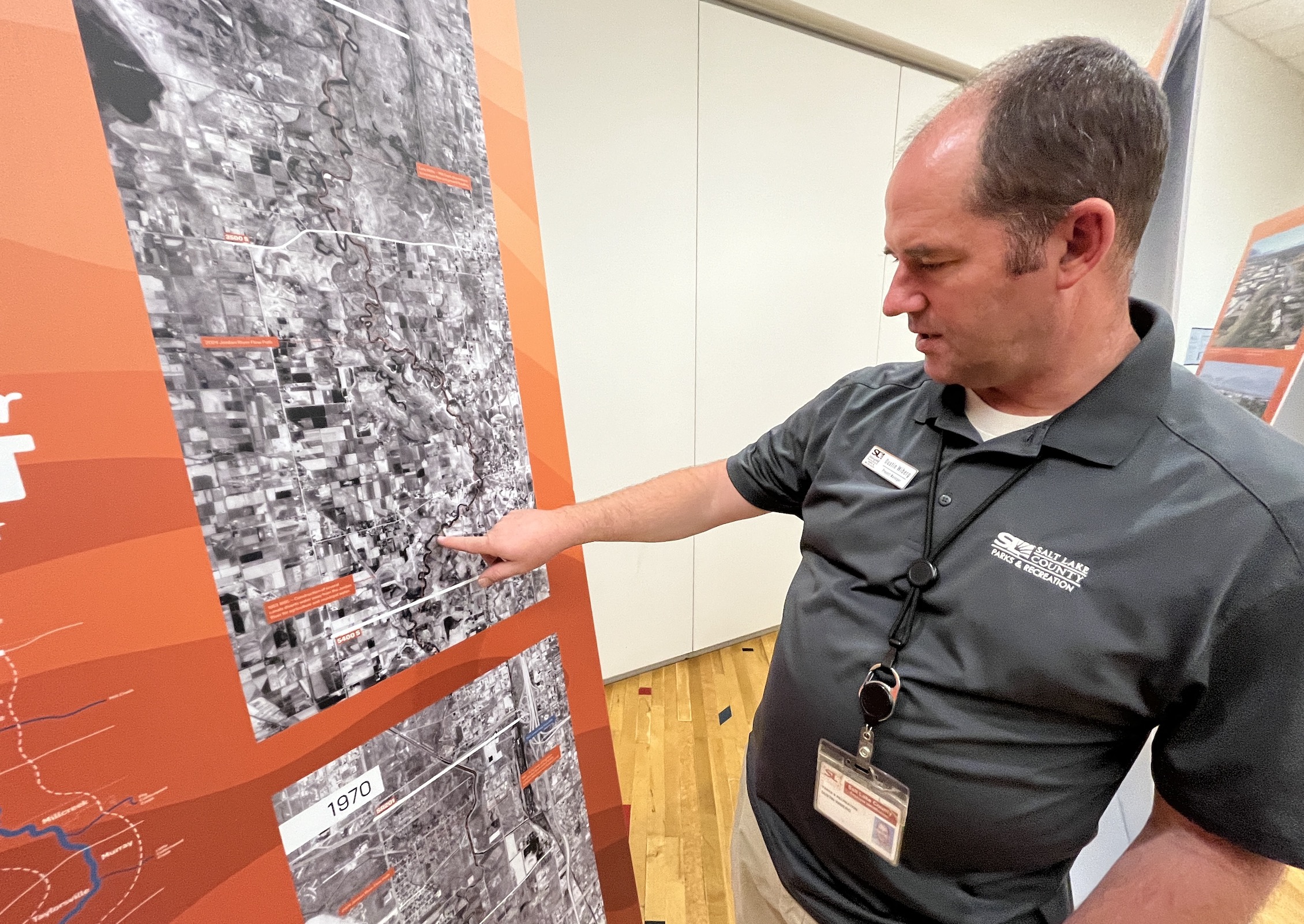 Dustin Wiberg, a park development project manager for Salt Lake County Parks and Recreation, points to a map showing the path of the Jordan River in 1937 and how it has changed since then.