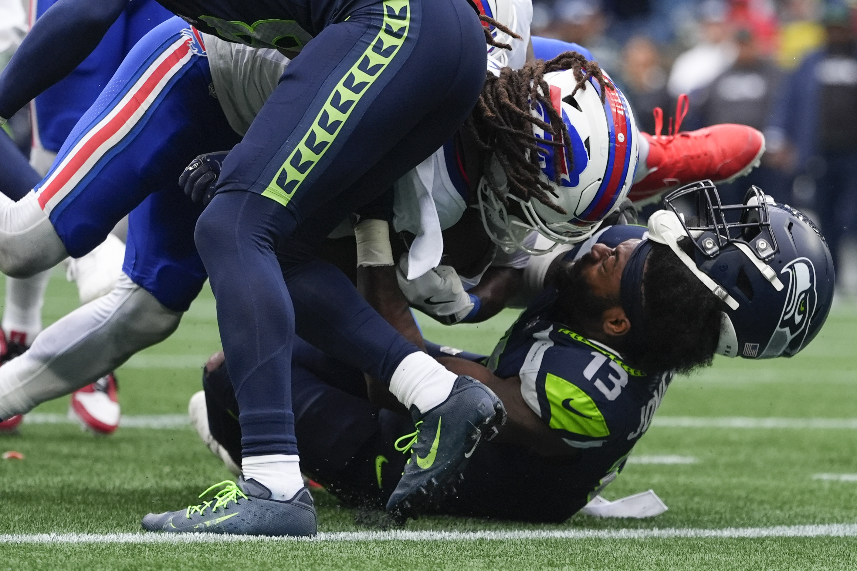 Seattle Seahawks linebacker Ernest Jones IV (13) has his helmet come off as Buffalo Bills running back James Cook (4) scores a touchdown during the second half of an NFL football game, Sunday, Oct. 27, 2024, in Seattle.