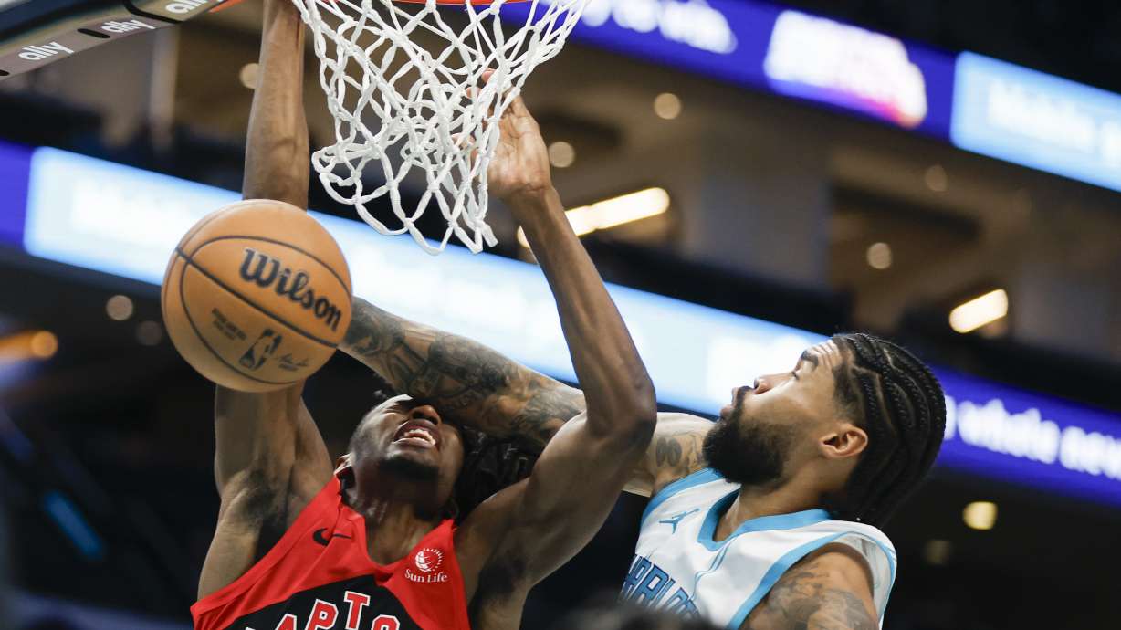 Toronto Raptors forward Jonathan Mogbo, left, collides with Charlotte Hornets center Nick Richards (4) as he drives to the basket during the first half of an NBA basketball game in Charlotte, N.C., Wednesday, Oct. 30, 2024.