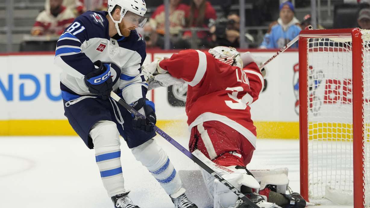 Winnipeg Jets left wing Kyle Connor (81) scores on Detroit Red Wings goaltender Alex Lyon (34) during the first period of an NHL hockey game, Wednesday, Oct. 30, 2024, in Detroit.