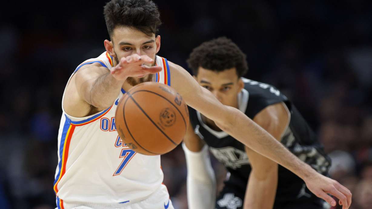 Oklahoma City Thunder forward Chet Holmgren (7) chases the ball in front of San Antonio Spurs center Victor Wembanyama during the first half of an NBA basketball game, Wednesday, Oct. 30, 2024, in Oklahoma City.