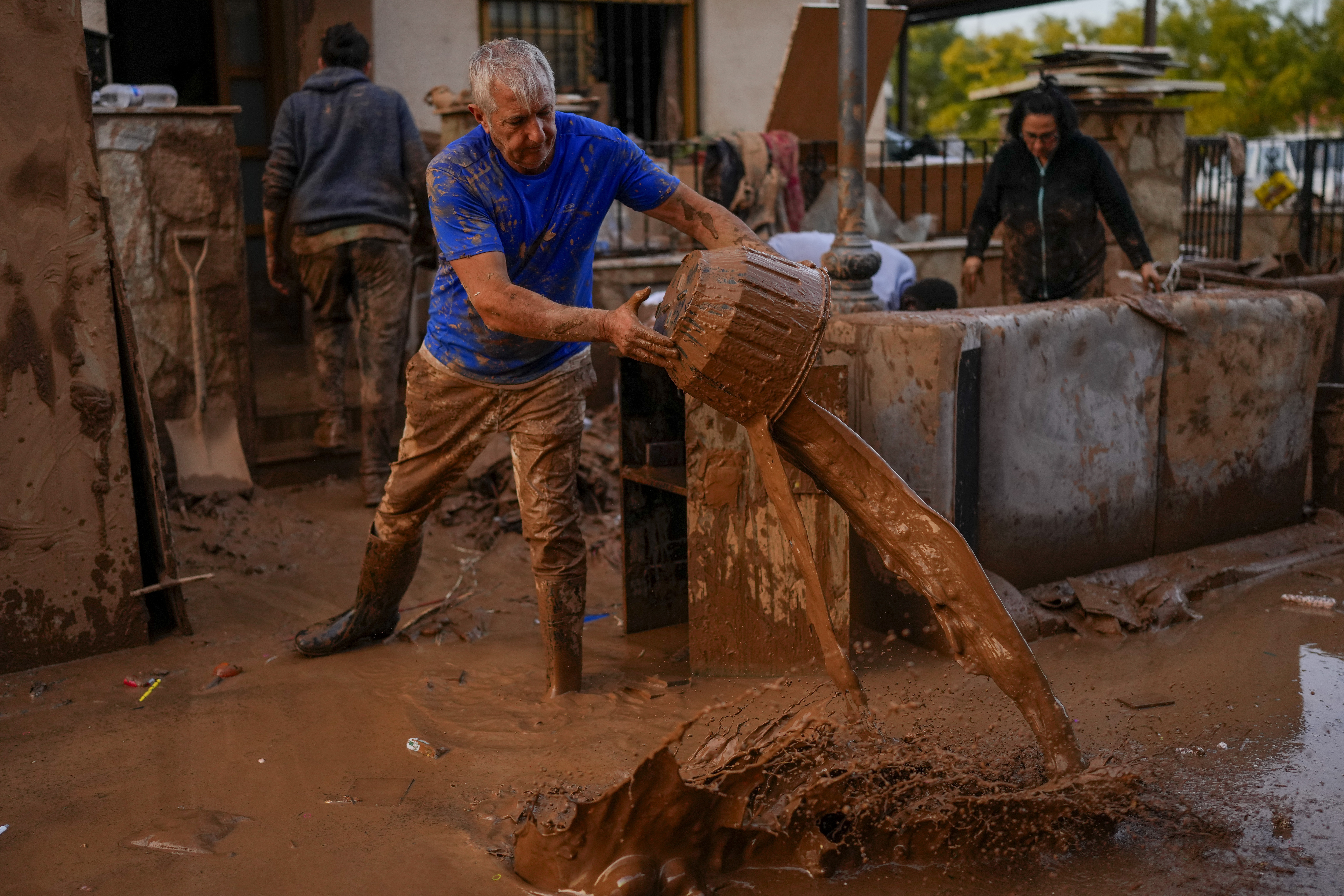 A man cleans his house affected by floods in Utiel, Spain, Wednesday.