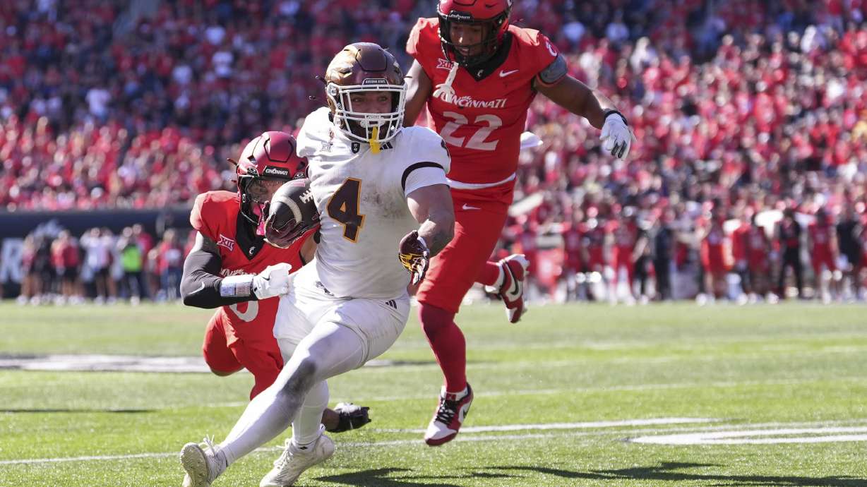 Arizona State's Cam Skattebo breaks a tackle by Cincinnati's Josh Minkins on a touchdown run during the second half of an NCAA college football game, Saturday, Oct. 19, 2024, in Cincinnati.