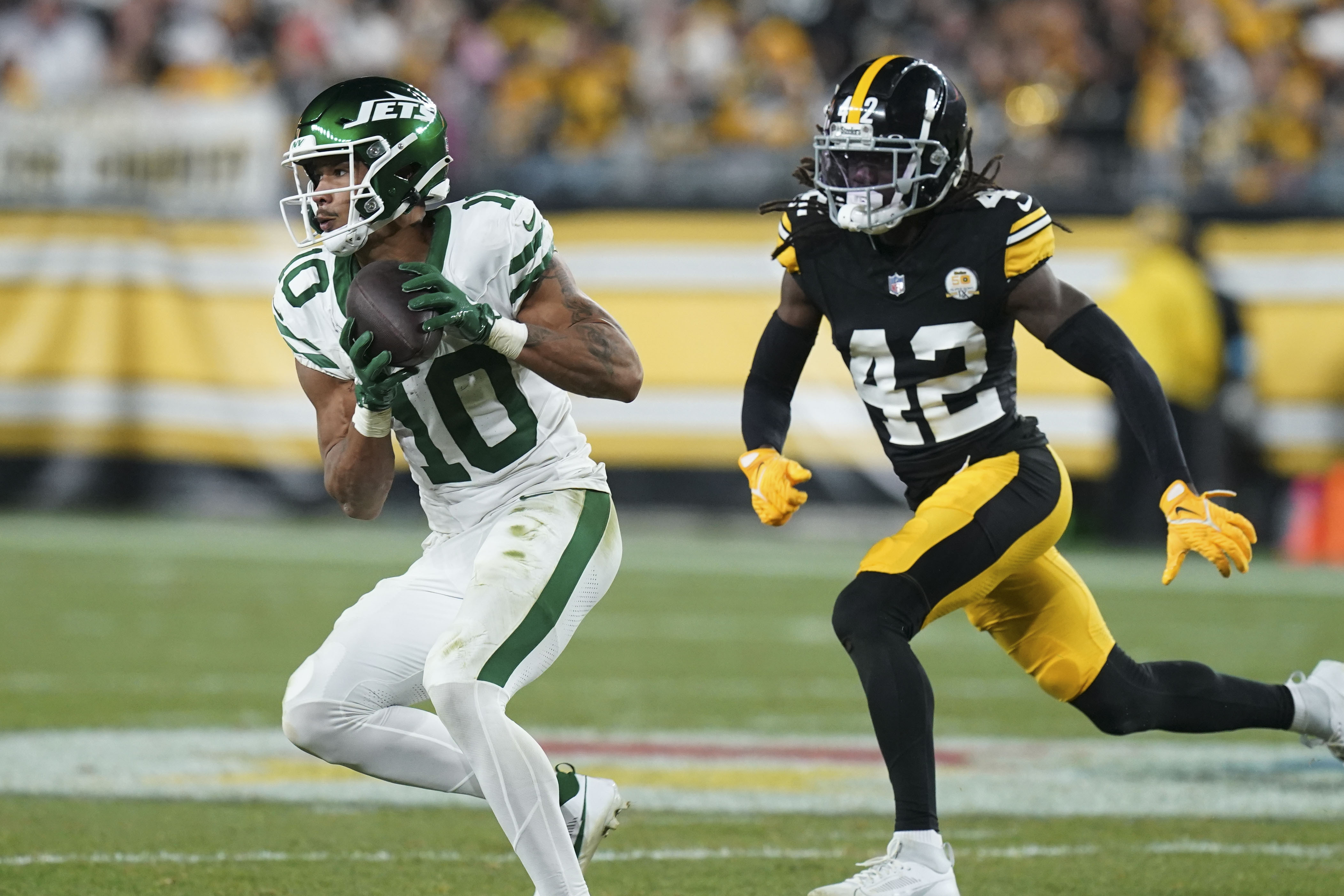 New York Jets wide receiver Allen Lazard (10) pulls in a pass against Pittsburgh Steelers cornerback James Pierre (42) in the second half of an NFL football game in Pittsburgh, Sunday, Oct. 20, 2024.
