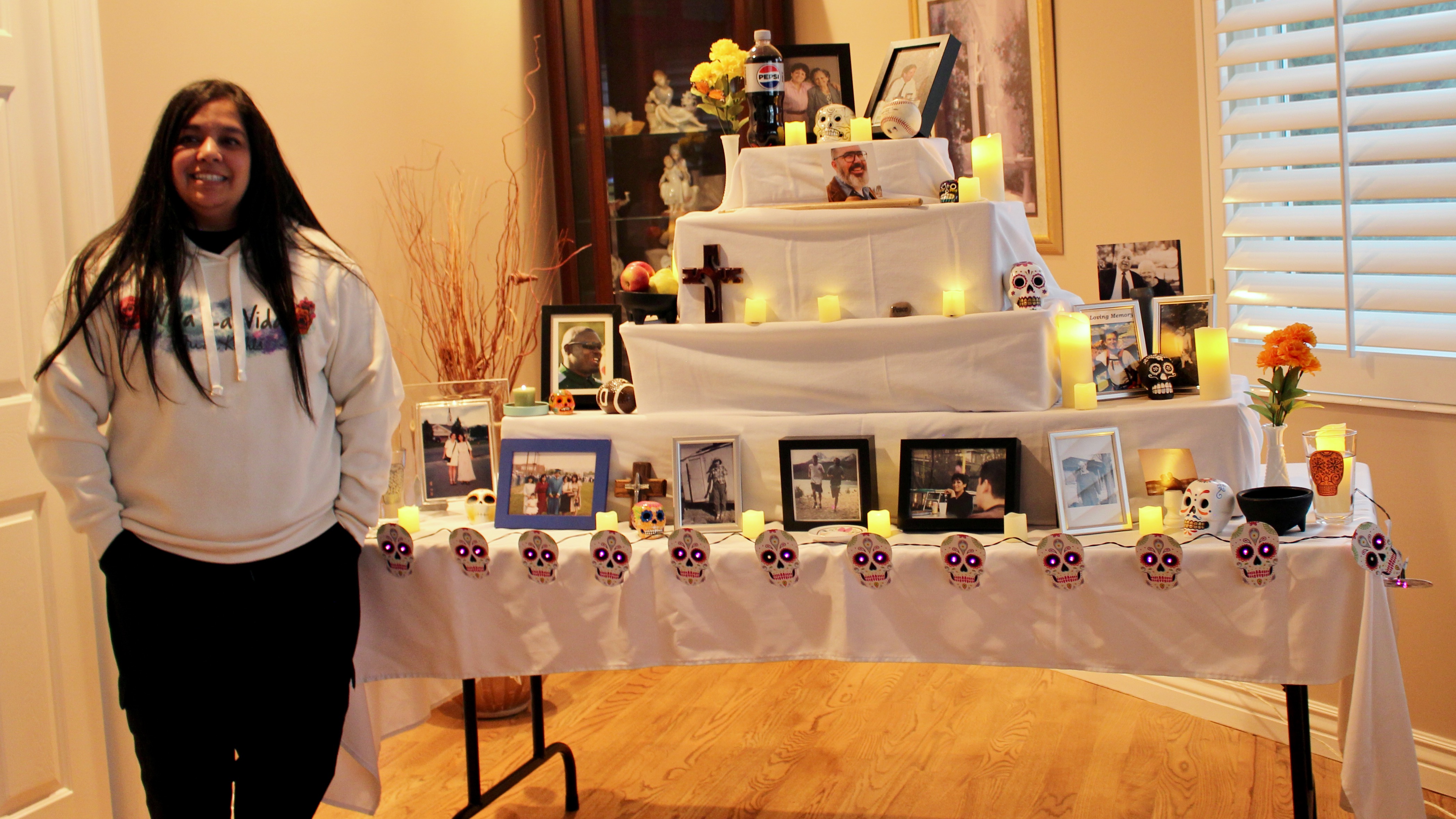 Areli Olsen and the ofrenda taking shape at her South Jordan home on Thursday. She started the tradition in the household of putting together an ofrenda to mark Día de los Muertos each year.