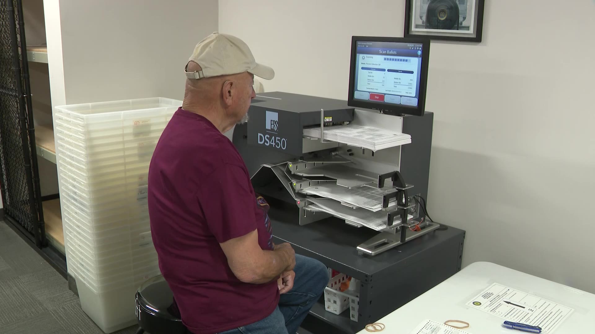 A poll worker feeds ballots into the scanner in Ogden on Thursday.