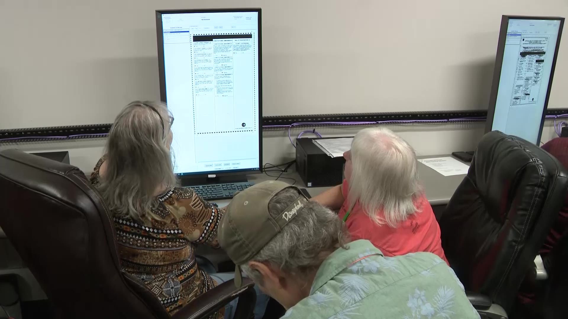 A team of three poll workers review a ballot to determine its voter's intent, Thursday in Ogden.