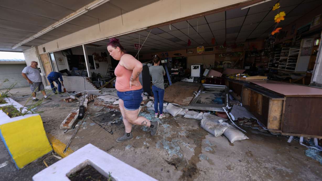 Kegan Ward walks through debris of a damaged store in the aftermath of Hurricane Helene, in Cedar Key, Fla., on Sept. 27. America's employers added just 12,000 jobs in October, influenced by the effects of strikes and hurricanes.