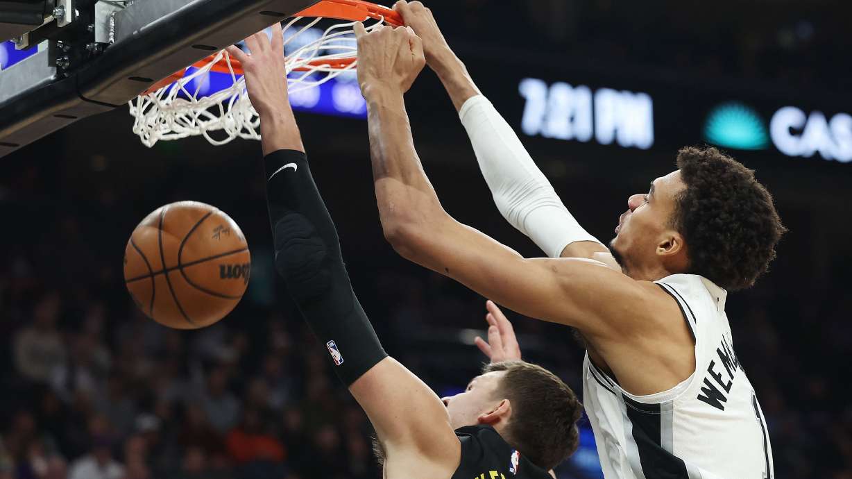 Utah Jazz center Walker Kessler (24) is dunked on by San Antonio Spurs center Victor Wembanyama (1) in Salt Lake City on Thursday, Oct. 31, 2024.