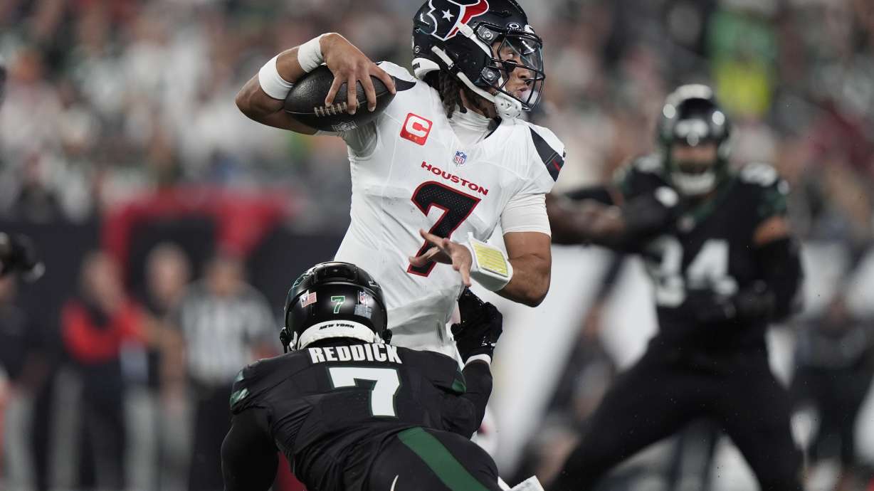 Houston Texans quarterback C.J. Stroud, top, evades a tackle by New York Jets defensive end Haason Reddick during the first half an NFL football game Thursday, Oct. 31, 2024, in East Rutherford, N.J.