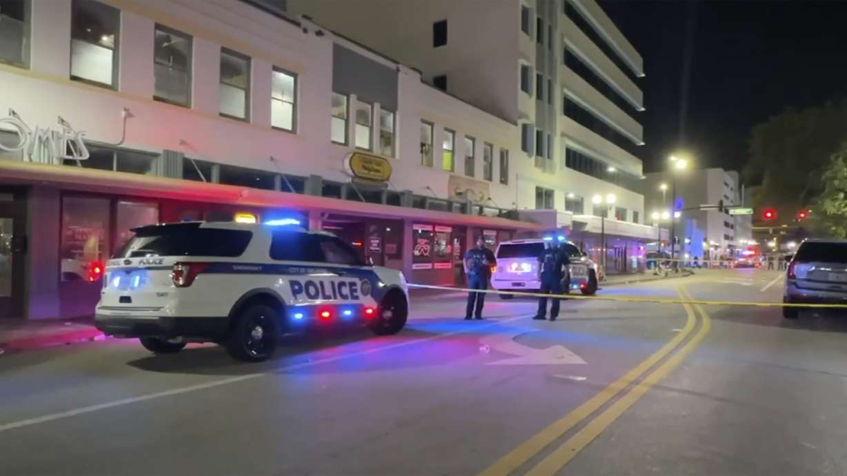 Police investigate the scene of two shootings that took place among crowds during Halloween celebrations early Friday in Orlando, Fla.