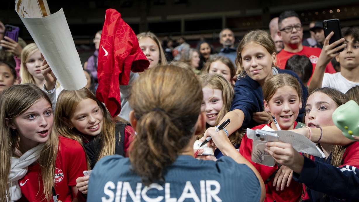 Portland Thorns FC's Christine Sinclair signs autographs for fans after a CONCACAF W Champions Cup match against the Vancouver Whitecaps in Vancouver, British Columbia, Tuesday, Oct. 15, 2024.