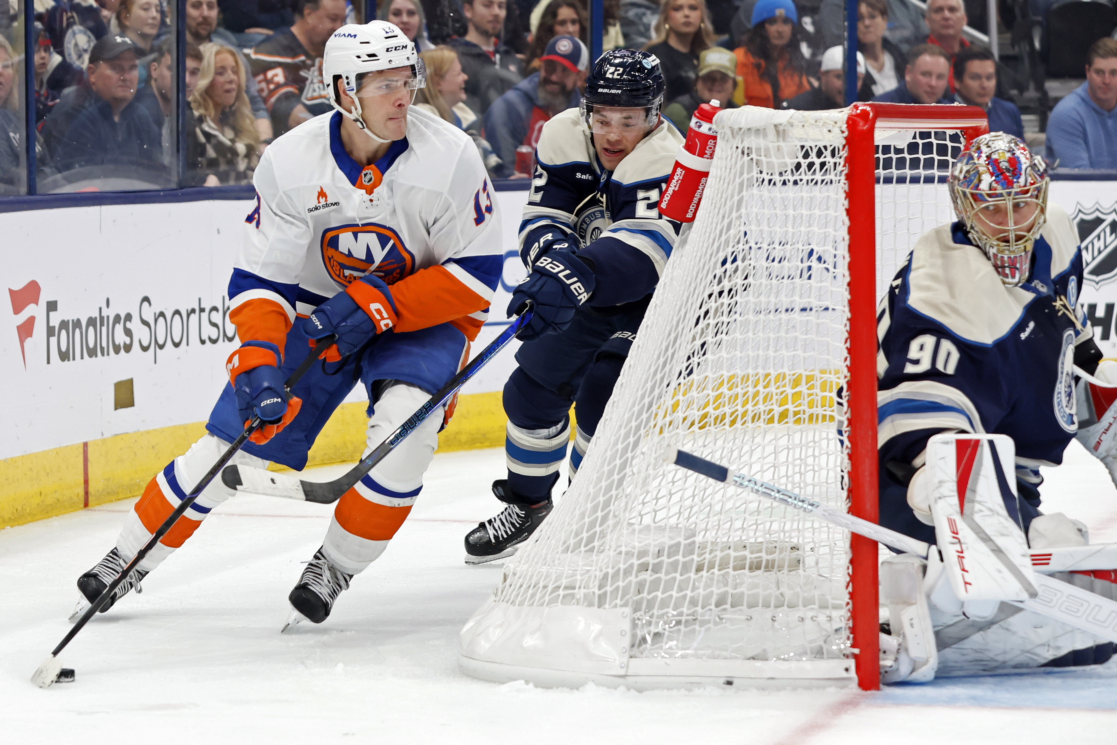 Columbus Blue Jackets' Elvis Merzlikins, right, protects the net as teammate Jordan Harris, center, chases New York Islanders' Mathew Barzal during the first period of an NHL hockey game Wednesday, Oct. 30, 2024, in Columbus, Ohio.