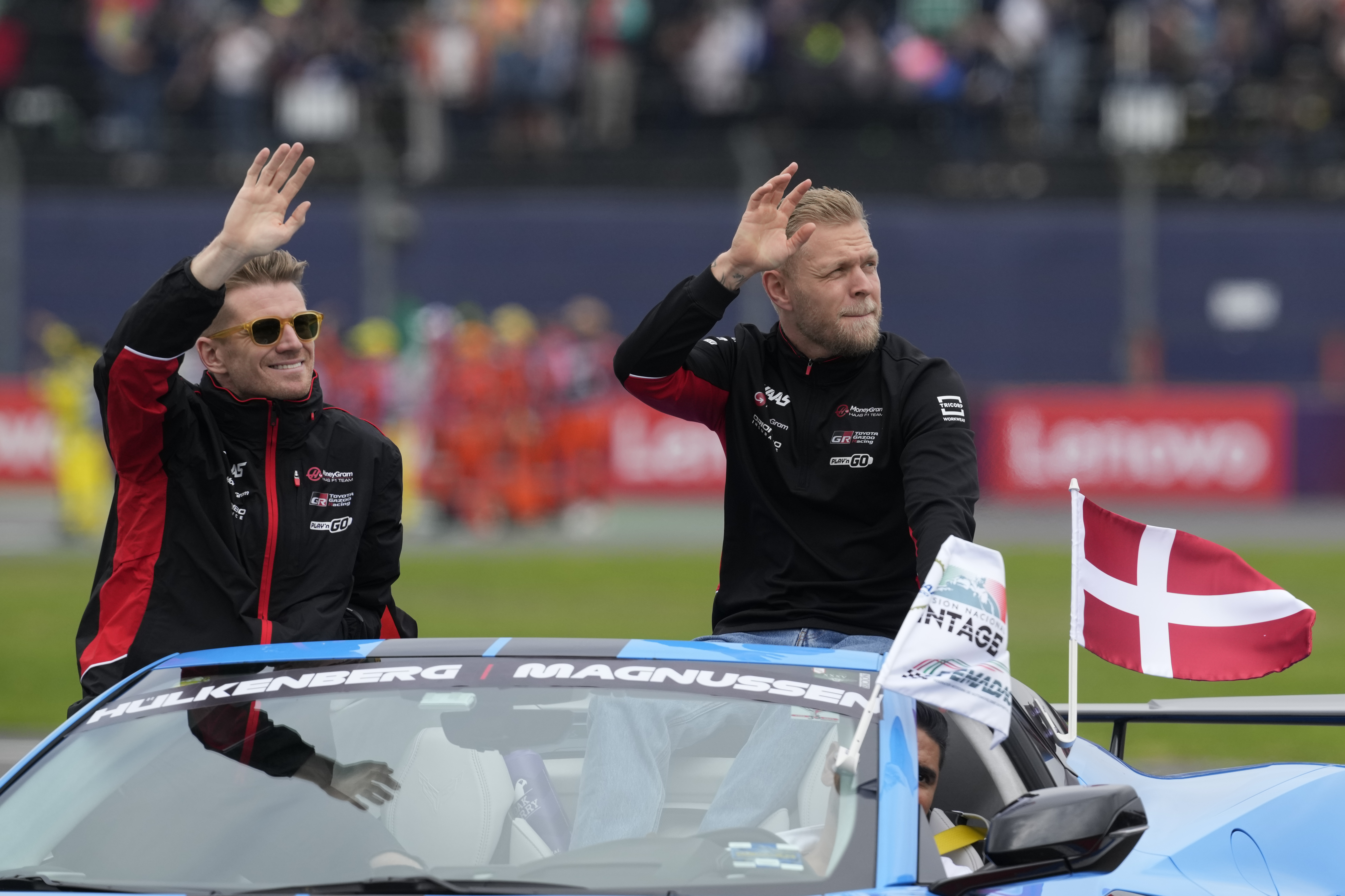 Haas driver Nico Hulkenberg of Germany, left, and teammate Kevin Magnussen of Denmark greet spectators during a parade before the Formula One Mexico Grand Prix auto race at the Hermanos Rodriguez racetrack in Mexico City, Sunday, Oct. 27, 2024.
