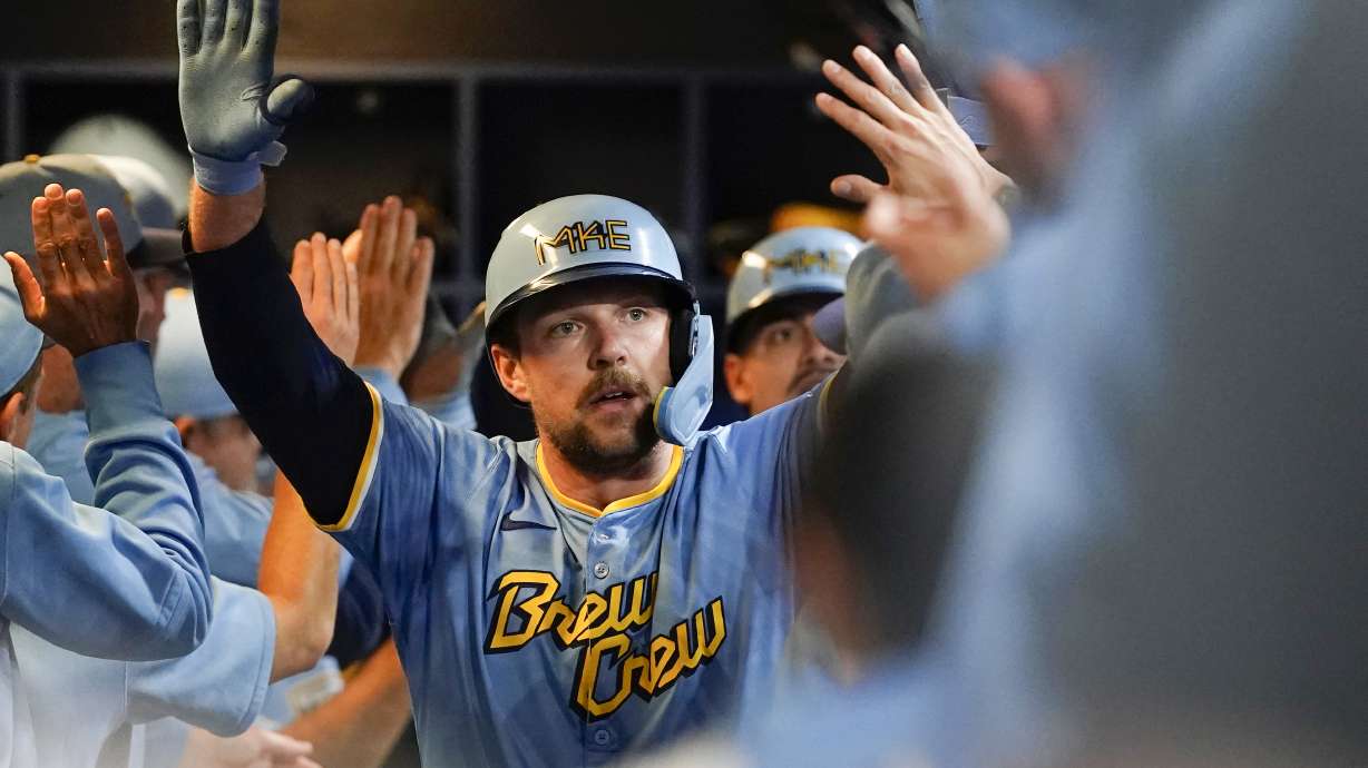 FILE - Milwaukee Brewers' Rhys Hoskins is congratulated in the dugout after hitting a grand slam during the first inning of a baseball game against the New York Mets, Sept. 27, 2024, in Milwaukee.