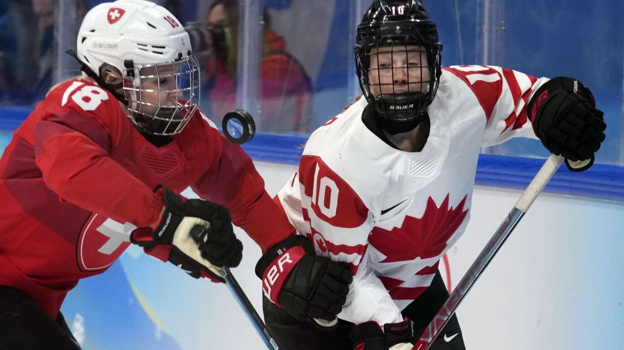 FILE - Switzerland's Stefanie Wetli (18) and Canada's Sarah Fillier (10) battle for the puck during a women's semifinal hockey game at the 2022 Winter Olympics, Monday, Feb. 14, 2022, in Beijing.