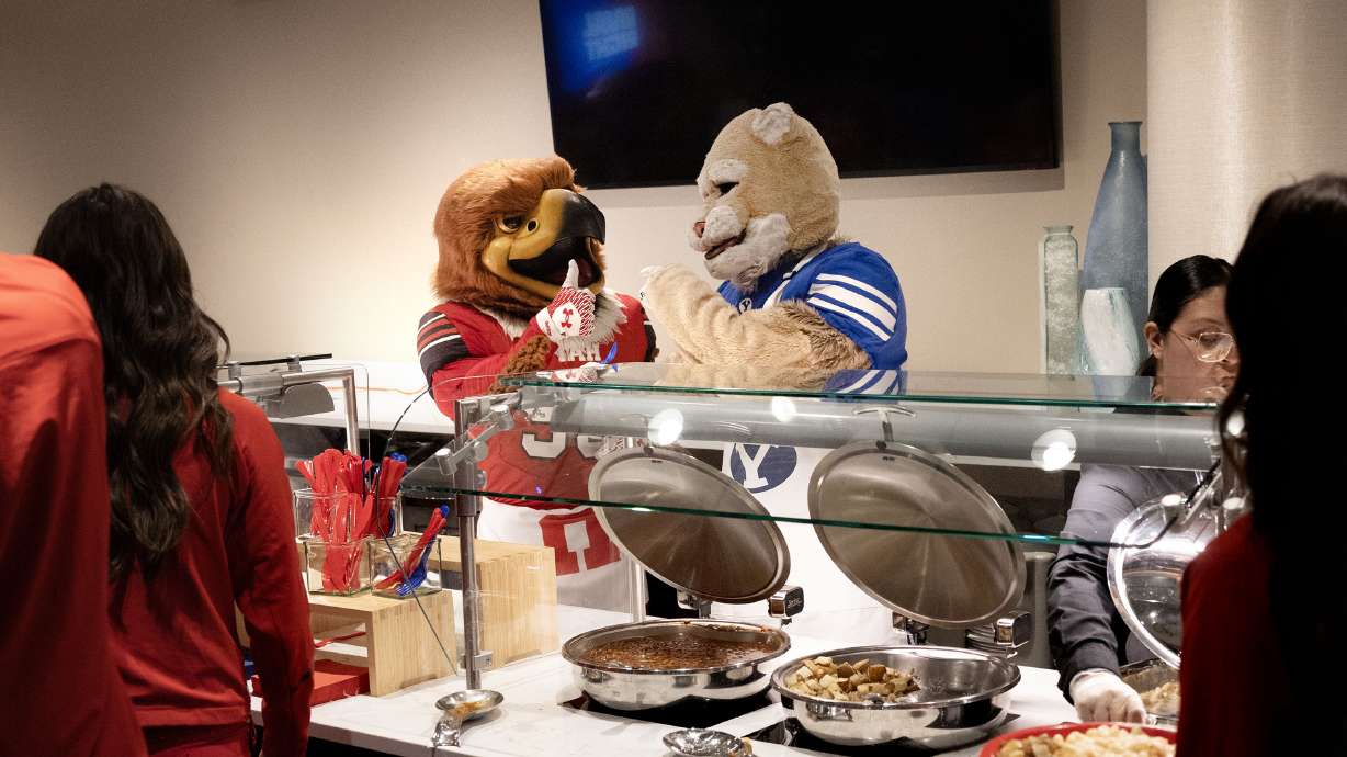 Swoop and Cosmo serve lunch at the Delta Center in Salt Lake City on Friday to attendees of a press conference announcing a joint service initiative with BYU and the University of Utah prior to their Nov. 9 game.