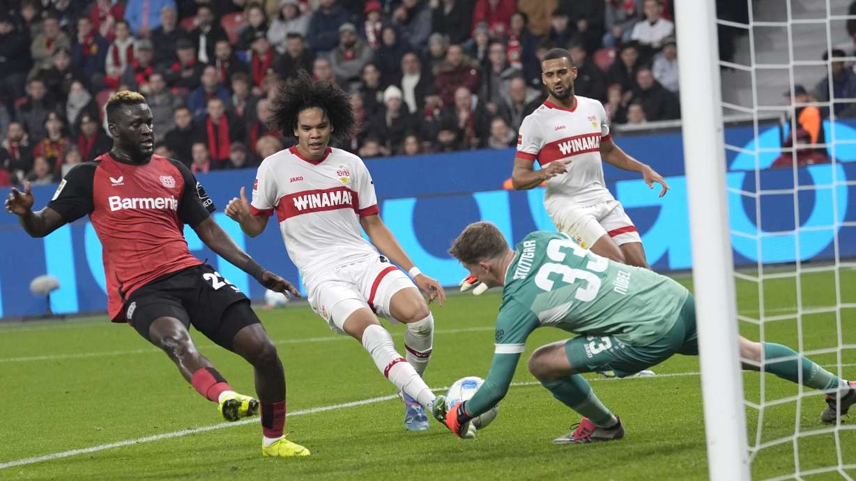 Leverkusen's Victor Boniface, left, makes an attempt to score past Stuttgart's goalkeeper Alexander Nuebel during the German Bundesliga soccer match between Bayer Leverkusen and VfB Stuttgart at the BayArena in Leverkusen, Germany, Friday, Nov. 1, 2024.