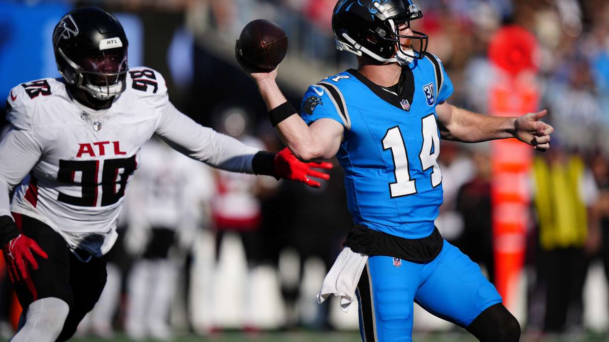 Carolina Panthers quarterback Andy Dalton (14) looks to pass against Atlanta Falcons defensive tackle Ruke Orhorhoro (98) in the first half of an NFL football game in Charlotte, N.C., Sunday, Oct. 13, 2024.