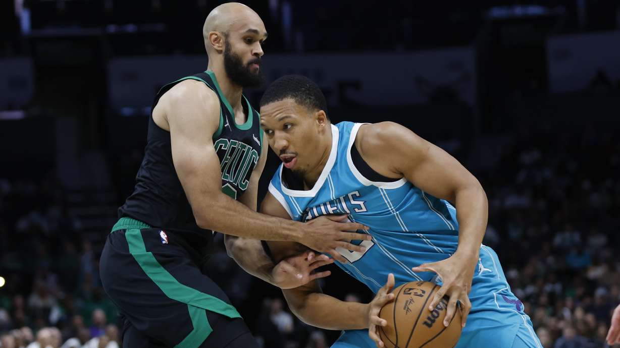 Charlotte Hornets forward Grant Williams, right, drives into Boston Celtics guard Derrick White during the first quarter of an NBA basketball game in Charlotte, N.C., Friday, Nov. 1, 2024.