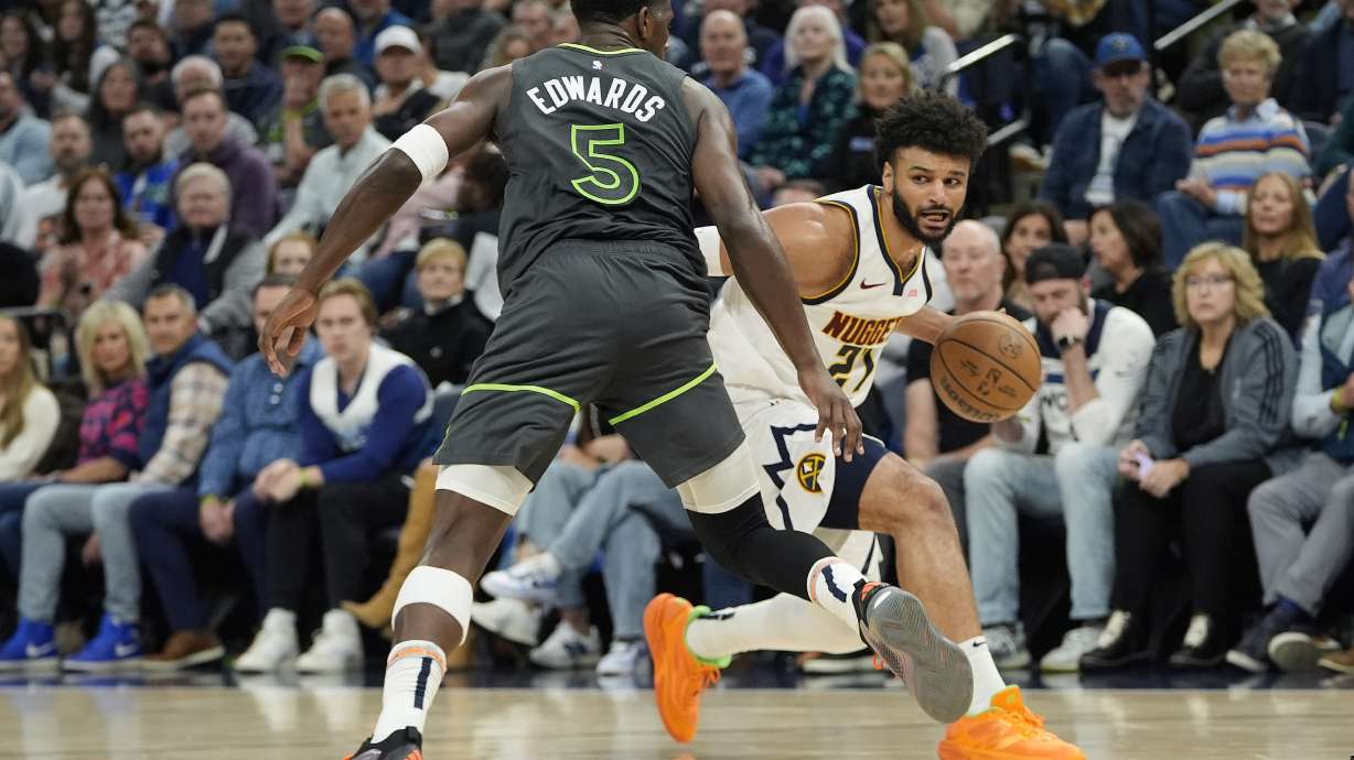 Denver Nuggets guard Jamal Murray (27) works toward the basket as Minnesota Timberwolves guard Anthony Edwards (5) defends during the first half of an NBA basketball game, Friday, Nov. 1, 2024, in Minneapolis.