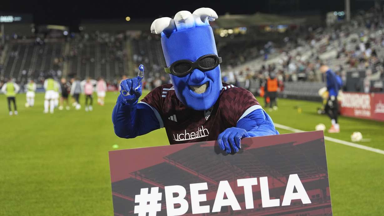 Colorado Rapids mascot Rapidman holds up a placard in the first half of the second match of an MLS Cup opening-round playoff series against the Los Angeles Galaxy Friday, Nov. 1, 2024, in Commerce City, Colo.