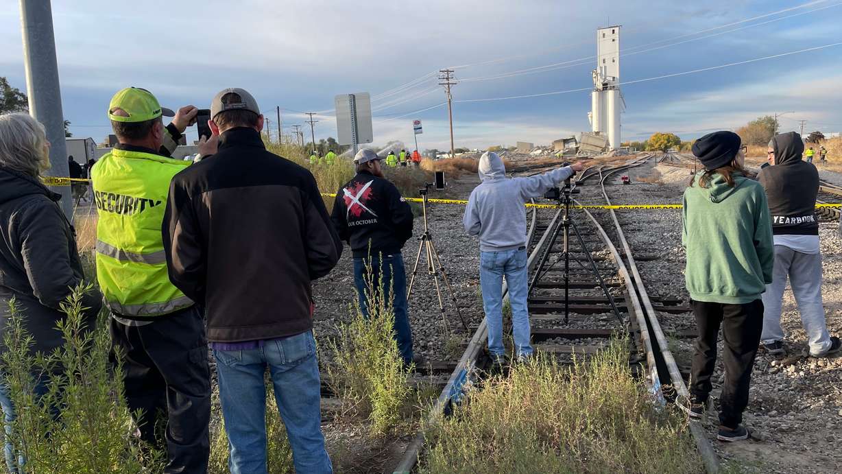 Spectators await demolition of the second of two head houses at the old Farmers Grain Cooperative grain elevator in Ogden that was blasted with explosives on Saturday.