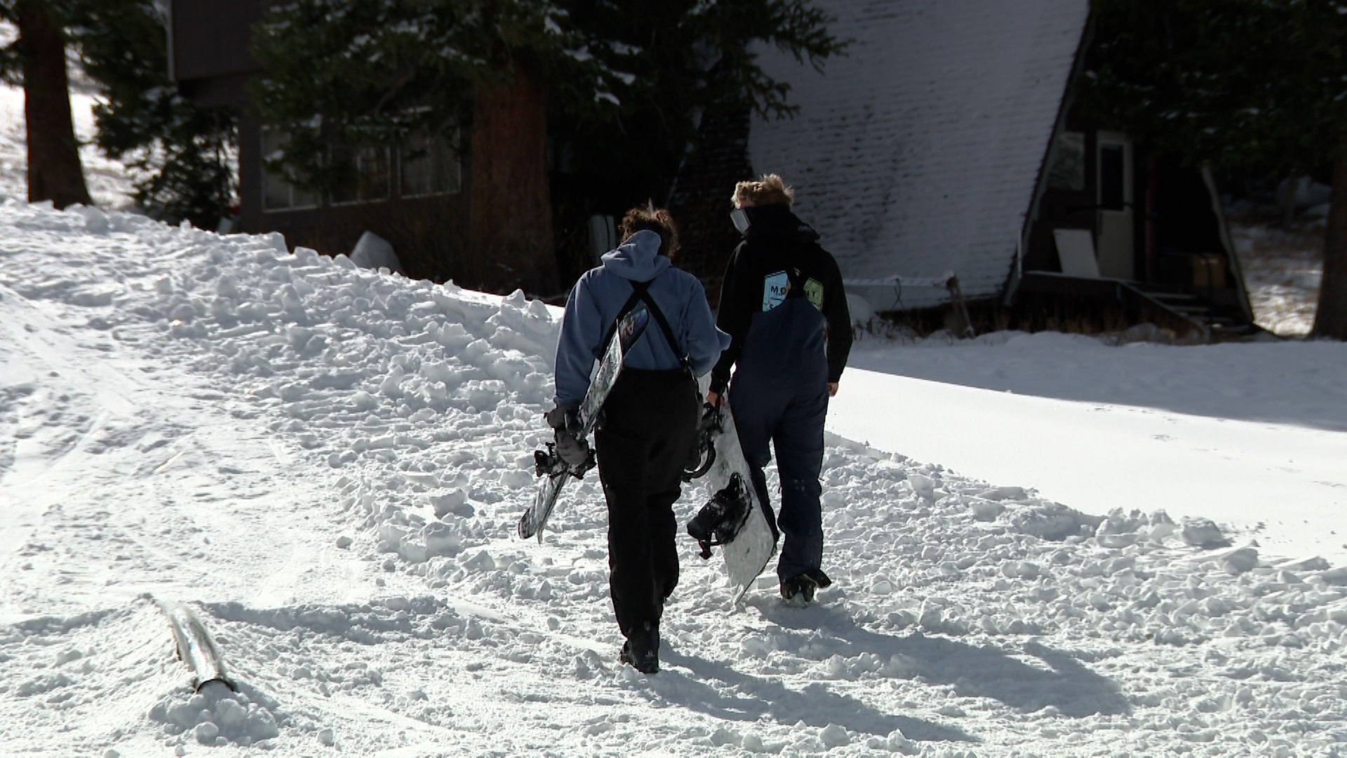 Van Hackett and Mike Connolly walk up the hill at Brighton Ski Resort Saturday, after curating their own runs at the resort, since it has yet to officially open.