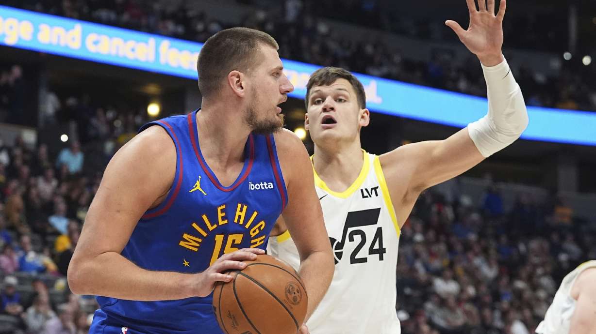 Denver Nuggets center Nikola Jokic, left, pulls in a rebound as Utah Jazz center Walker Kessler defends in the second half of an NBA basketball game Saturday, Nov. 2, 2024, in Denver.