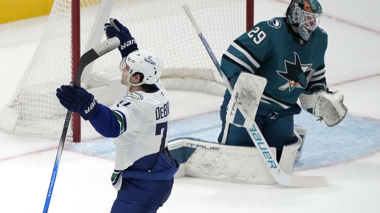 Vancouver Canucks left wing Jake DeBrusk, left, celebrates after scoring a goal against San Jose Sharks goaltender Mackenzie Blackwood (29) during the third period of an NHL hockey game in San Jose, Calif., Saturday, Nov. 2, 2024.