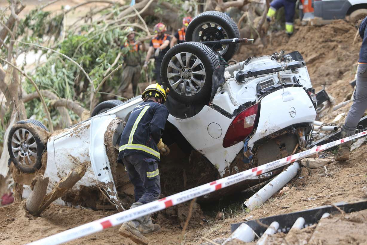 A rescue worker checks a car after floods in Paiporta near Valencia, Spain, Sunday.