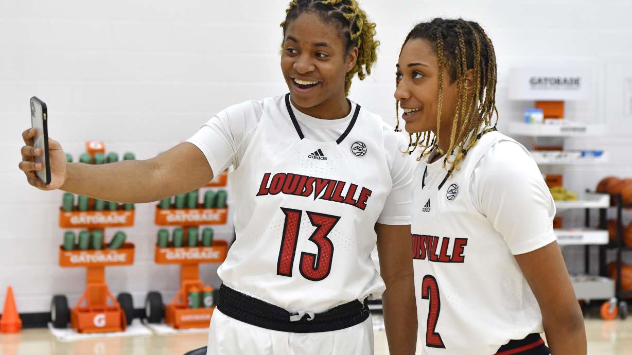 FILE - Louisville forward Melissa Russell (13) interviews guard Ahlana Smith (2) during the team's NCAA college basketball media day in Louisville, Ky., Oct. 26, 2021.