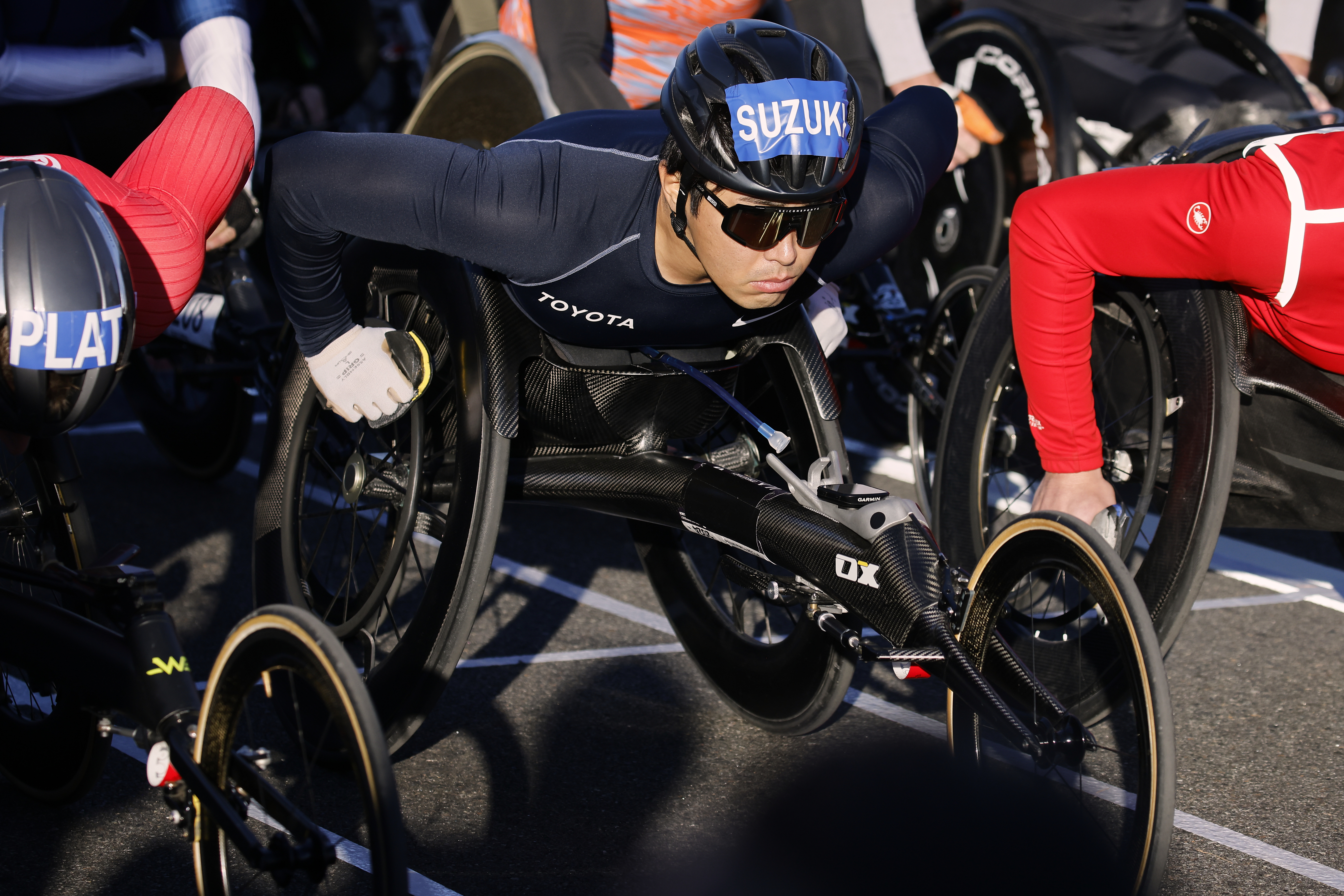 Tomoki Suzuki, center, of Japan, pushes off at the start of men's wheelchair dividing during the New York City Marathon, Sunday, Nov. 3, 2024, in New York.