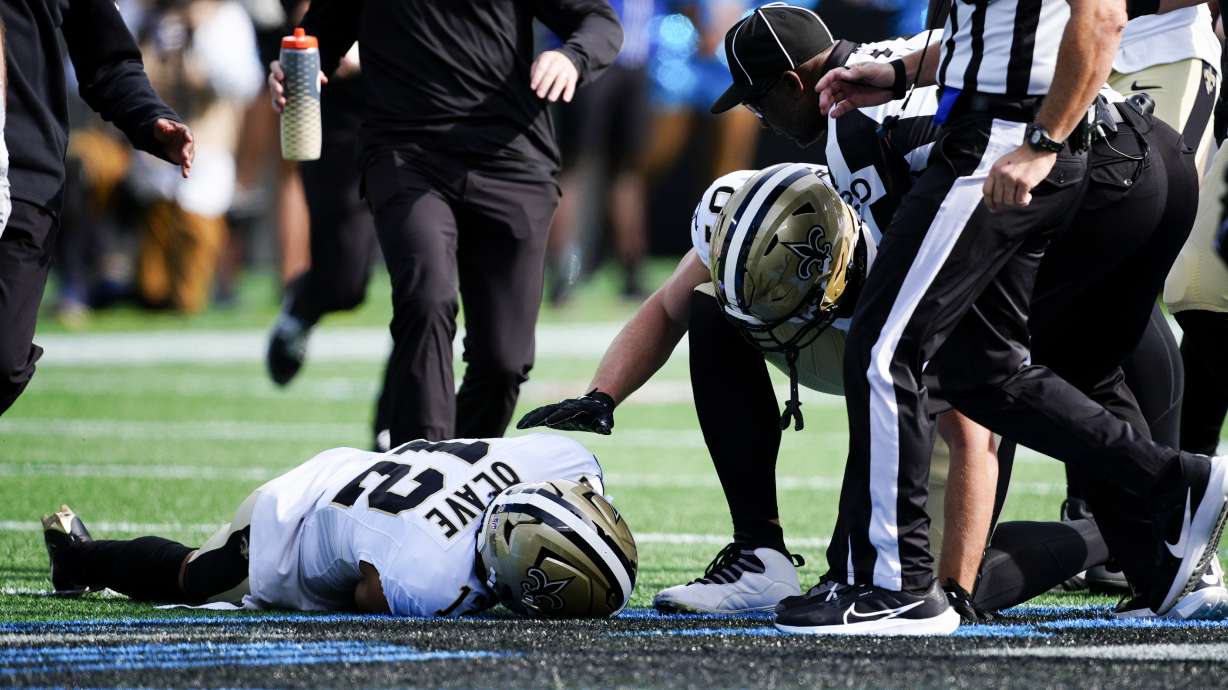 New Orleans Saints wide receiver Chris Olave in comforted by wide receiver Deven Thompkins during the first half of an NFL football game against the Carolina Panthers Sunday, Nov. 3, 2024, in Charlotte, N.C. Olave was taken off the field after getting hurt on the play.