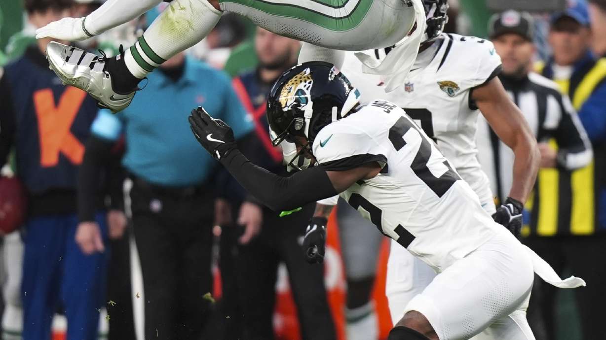 Philadelphia Eagles running back Saquon Barkley (26) leaps over Jacksonville Jaguars cornerback Jarrian Jones (22) during the first half of an NFL football game Sunday, Nov. 3, 2024, in Philadelphia.