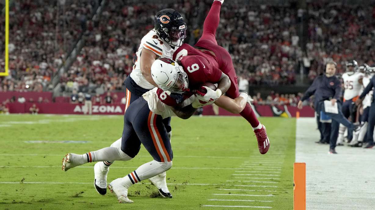 Arizona Cardinals running back James Conner (6) is stopped by Chicago Bears defensive end Austin Booker, left, and Chicago Bears defensive tackle Andrew Billings during the first half of an NFL football game, Sunday, Nov. 3, 2024, in Glendale, Ariz.