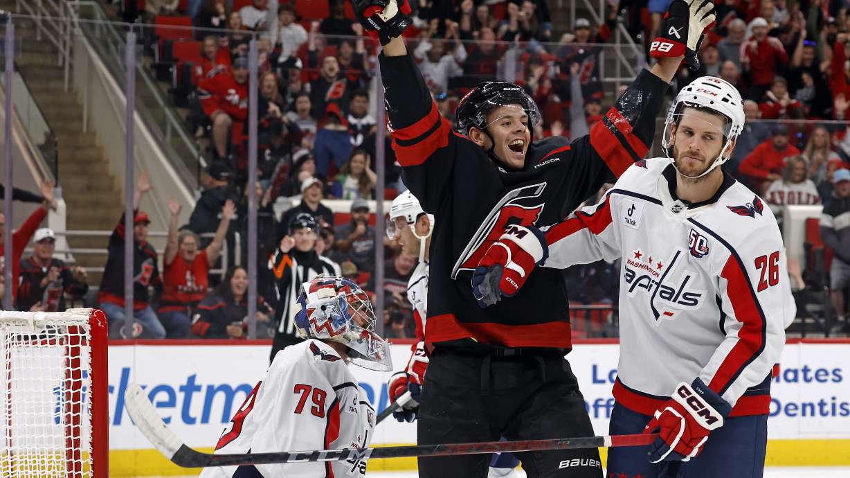 Carolina Hurricanes' Jesperi Kotkaniemi, center, celebrates after a goal by teammate Dmitry Orlov between Washington Capitals goaltender Charlie Lindgren (79) and Nic Dowd (26) during the first period of an NHL hockey game in Raleigh, N.C., Sunday, Nov. 3, 2024.