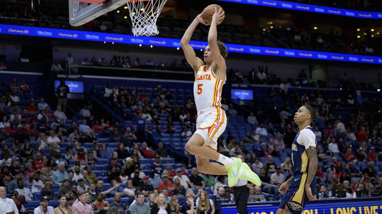 Atlanta Hawks guard Dyson Daniels (5) goes for an open dunk against New Orleans Pelicans guard Jordan Hawkins, right, during the second half of an NBA basketball game in New Orleans, Sunday, Nov. 3, 2024.
