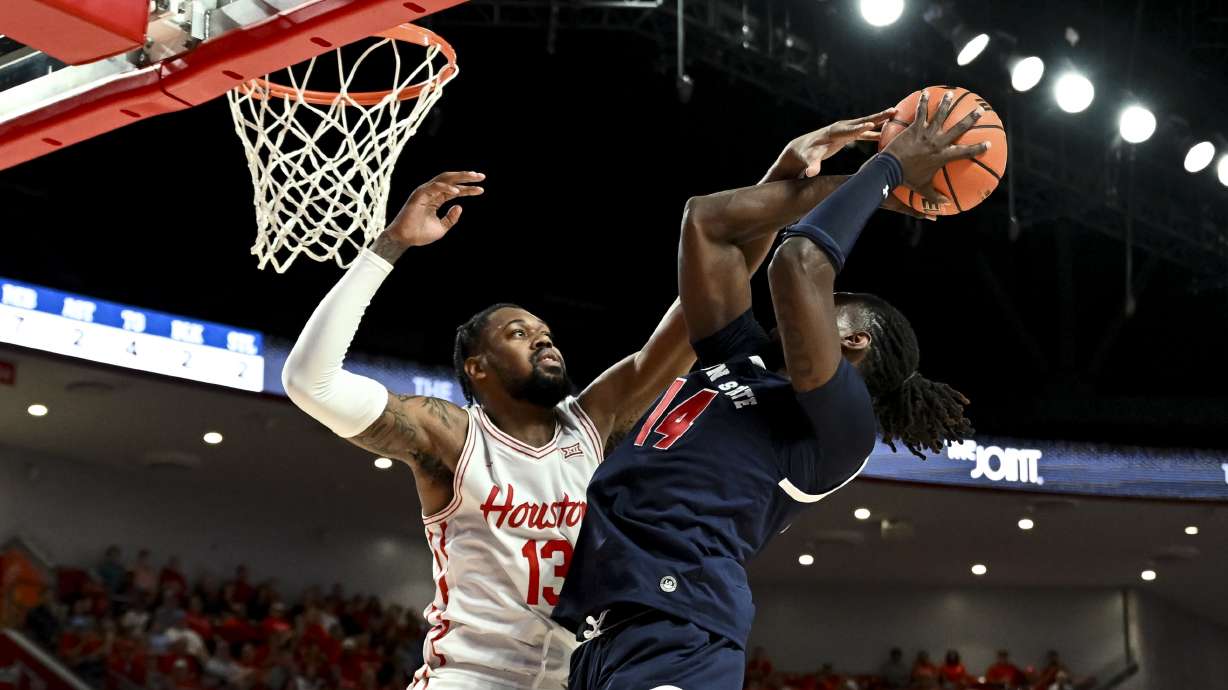 Houston forward J'Wan Roberts (13) blocks Jackson State forward Dylan Canoville (14) shot during the first half of an NCAA college basketball game, Monday, Nov 4, 2024, in Houston.