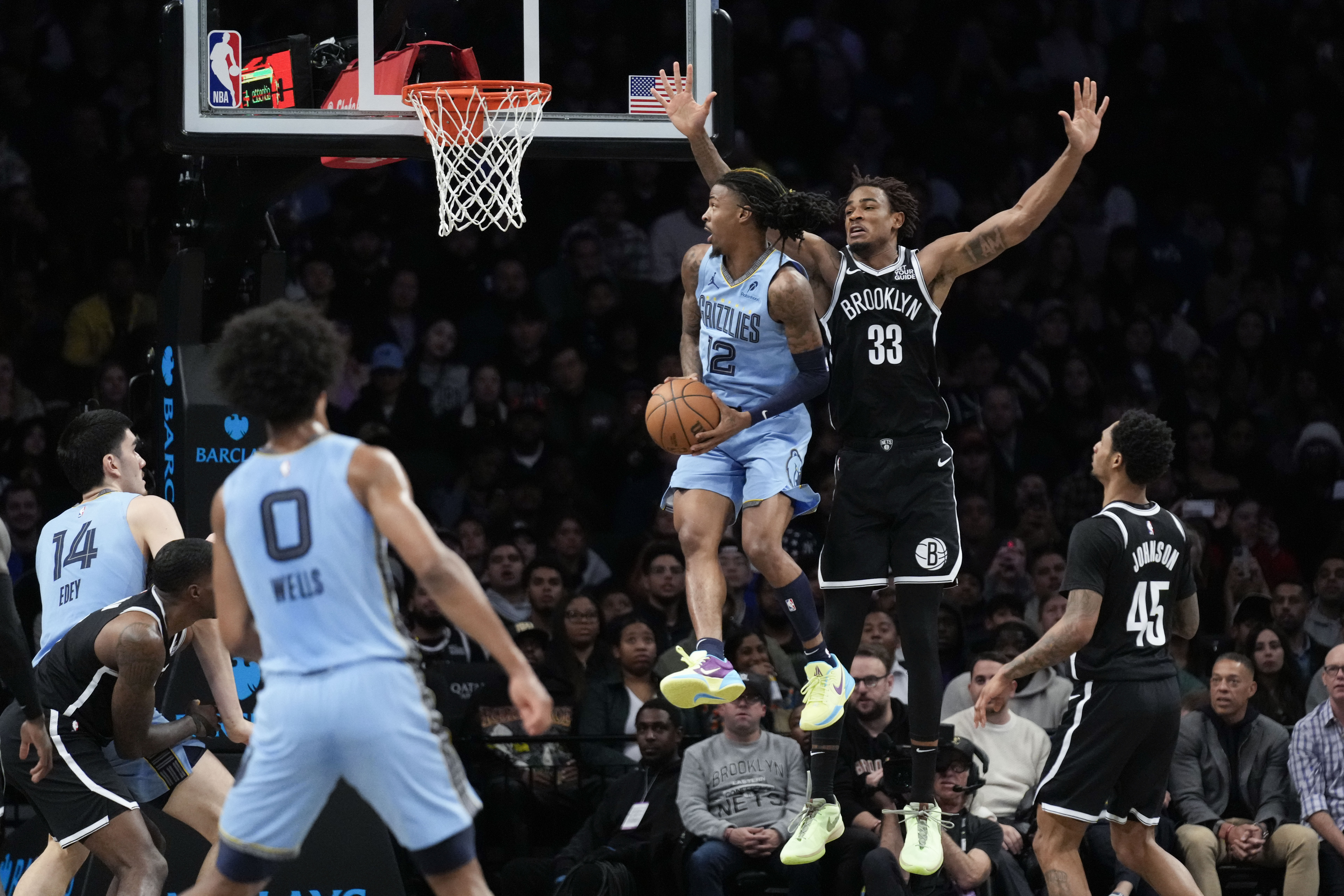 Memphis Grizzlies' Ja Morant (12) spins around Brooklyn Nets' Nic Claxton (33) during the first half of an NBA basketball game, Monday, Nov. 4, 2024, in New York.
