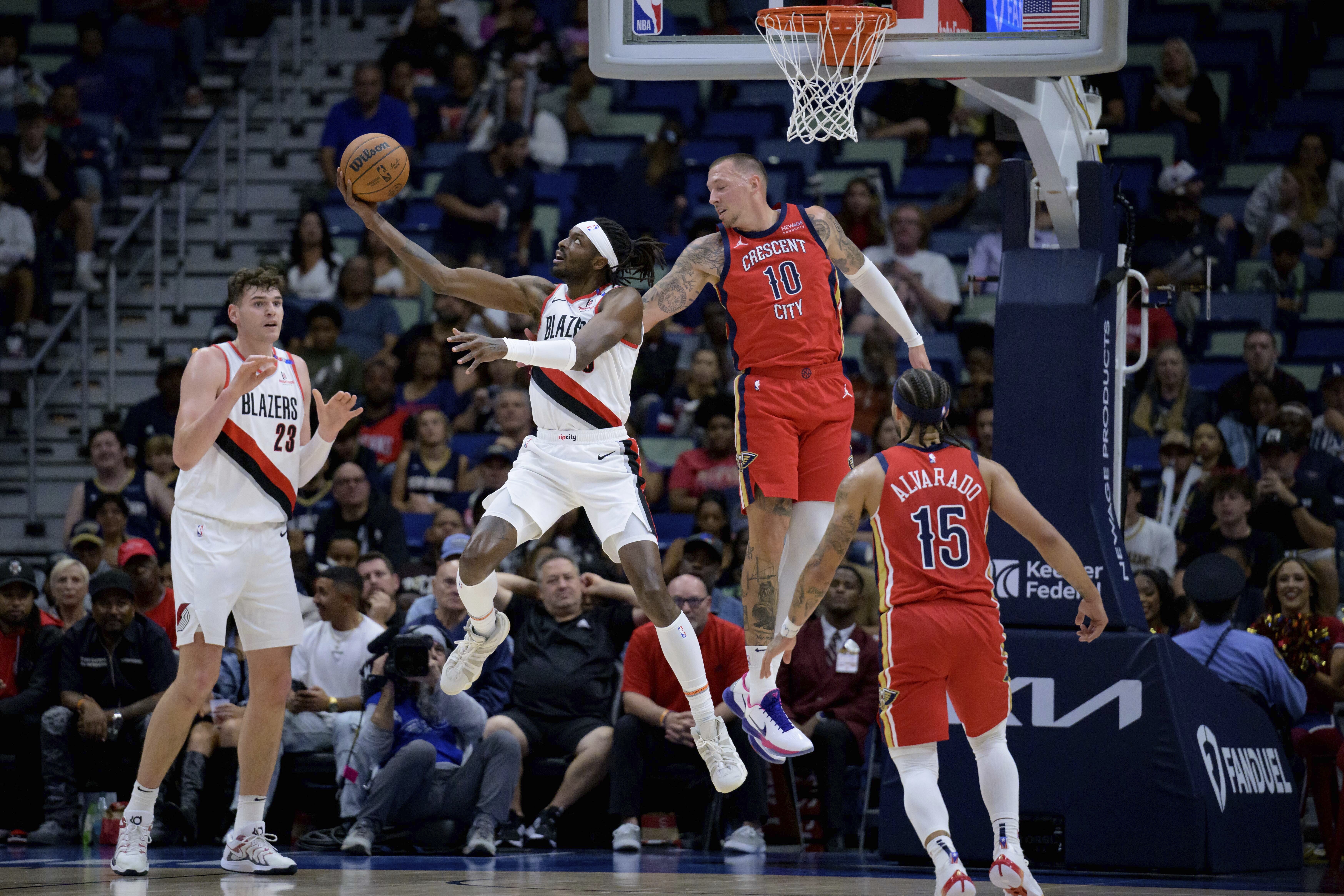 Portland Trail Blazers forward Jerami Grant (9) shoots around New Orleans Pelicans center Daniel Theis (10) during the first half of an NBA basketball game in New Orleans, Monday, Nov. 4, 2024.
