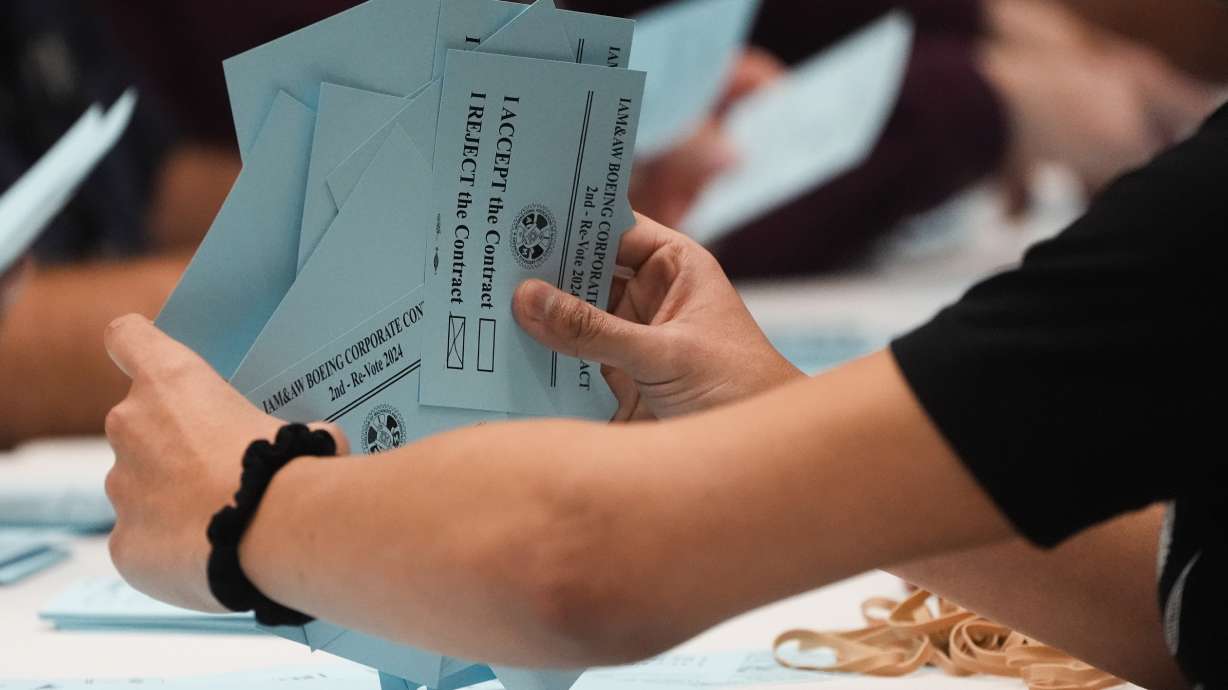A volunteer sorts votes on a new contract offer from Boeing, Monday, in Seattle. Boeing's unionized machinists voted on Monday to accept a company contract, ending a more than seven week old strike.
