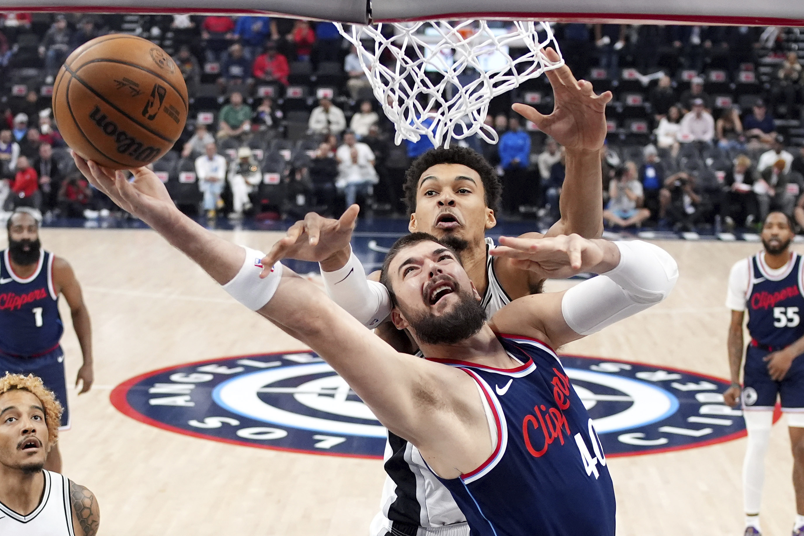 Los Angeles Clippers center Ivica Zubac, below, shoots as San Antonio Spurs center Victor Wembanyama defends during the first half of an NBA basketball game, Monday, Nov. 4, 2024, in Inglewood, Calif.