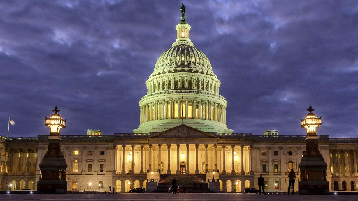 FILE - Lights shine inside the U.S. Capitol Building as night falls on Jan. 21, 2018, in Washington.