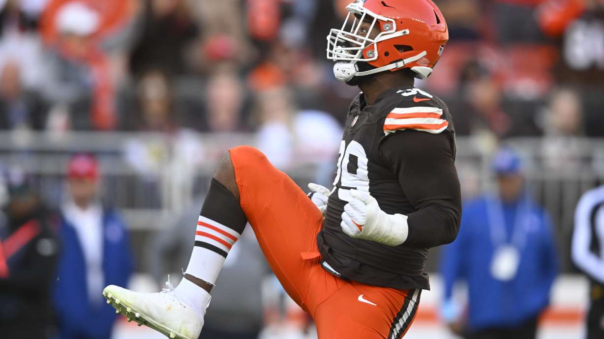 Cleveland Browns defensive end Za'Darius Smith (99) celebrates a sack of Baltimore Ravens quarterback Lamar Jackson (8) during the second half of an NFL football game in Cleveland, Sunday, Oct. 27, 2024.