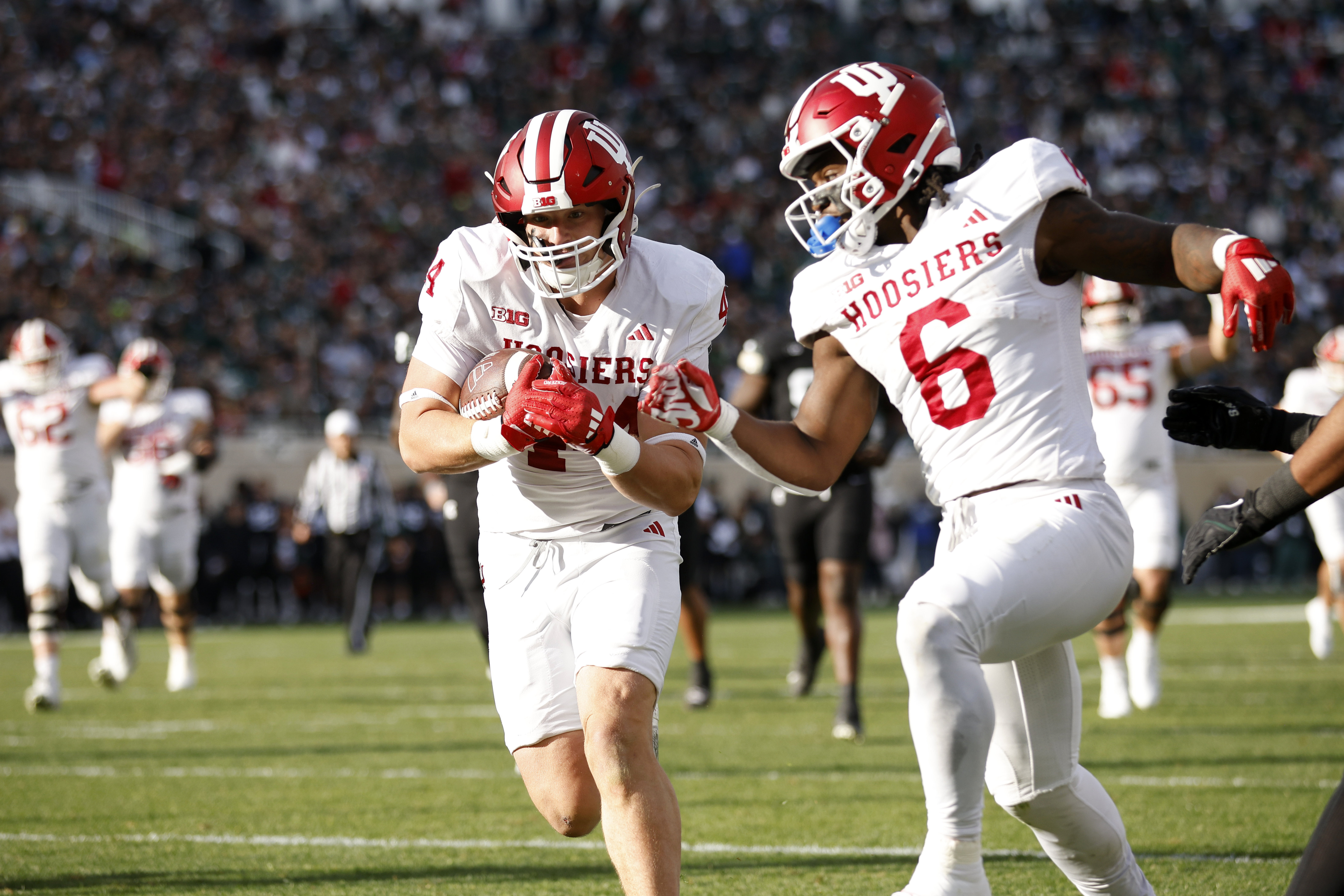 Indiana tight end Zach Horton, left, scores on a pass reception as Indiana running back Justice Ellison (6) looks on during the first half of an NCAA college football game against Michigan State, Saturday, Nov. 2, 2024, in East Lansing, Mich.
