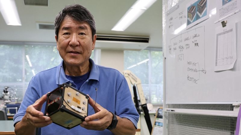 Takao Doi, a former Japanese astronaut and professor at Kyoto University, holds an engineering model of LignoSat at his laboratory at Kyoto University in Kyoto, Japan, Oct. 25. The world's first wooden satellite was launched into space Tuesday.