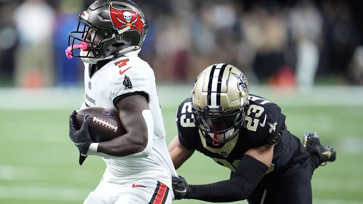 Tampa Bay Buccaneers running back Bucky Irving (7) runs against New Orleans Saints cornerback Marshon Lattimore (23) during the first half of an NFL football game in New Orleans, Sunday, Oct. 13, 2024.