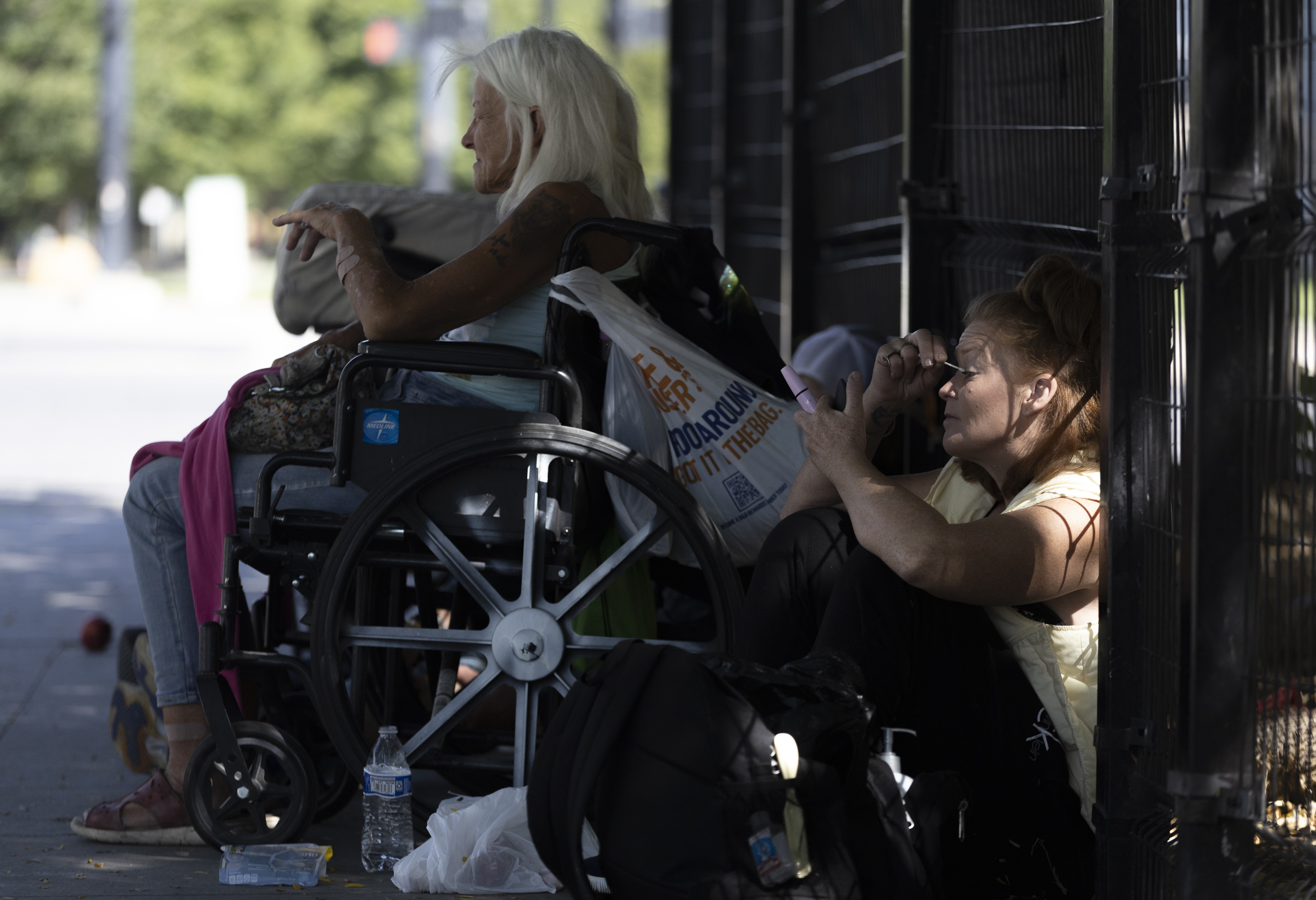 Krissi, who has been homeless for 10 years, applies makeup while sitting with her friend Nancy in the shade in the Rio Grande neighborhood of downtown Salt Lake City on Sept. 9.